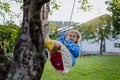 A young girl swinging on a swing in the garden. Royalty Free Stock Photo