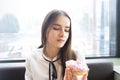 Young girl at a table in a cafe quit diet, eating pastries