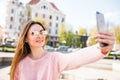 Young girl take selfie from hands with phone on summer city street. Urban life concept. Royalty Free Stock Photo