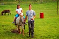 A young girl takes a donkey ride on a farm