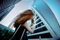 Young girl takes a picture of High tall building on his smartphone.