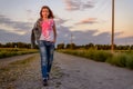 Young girl taking an evening walk in the country Royalty Free Stock Photo