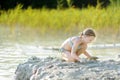 Young girl taking healing mud baths on lake Gela near Vilnius, Lithuania. Child having fun with mud. Kid playing with clay Royalty Free Stock Photo