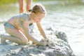 Young girl taking healing mud baths on lake Gela near Vilnius, Lithuania. Child having fun with mud. Kid playing with clay Royalty Free Stock Photo