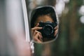 young girl taking photo on camera through mirror of Royalty Free Stock Photo