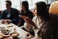 Young company is having fun and eating in bar. smoking a hookah, communicating in an oriental restaurant. Royalty Free Stock Photo