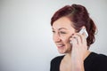 A young girl talking on a cell phone with a smile on her face, a white background, facial expressions Royalty Free Stock Photo