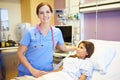 Young Girl Talking To Female Nurse In Hospital Room