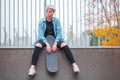 A girl is sitting on top of an overclock with a skate in her hand Royalty Free Stock Photo