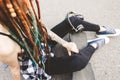 Young girl with tattoo and dreadlocks sitting in the park Royalty Free Stock Photo