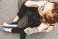 Young girl with tattoo and dreadlocks sitting in the park Royalty Free Stock Photo