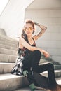 Young girl with tattoo and dreadlocks sitting on the steps