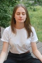 Young girl, teen ager sitting lotus position, meditating. Summer day. Education concept
