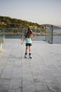 Young girl, teenager, rollerblading near the sea. Green T-shirt, colored hair. Funtime