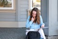 young girl teenager sits on porch in hands with a folder, a magazine and pencil, do homework, solve problems, wait at Royalty Free Stock Photo