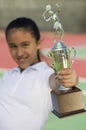 Young girl on tennis court holding trophy focus on trophy Royalty Free Stock Photo