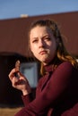 A young girl is thoughtful and eats chocolate in nature.