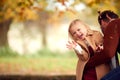 Young Girl Throwing Autumn Leaves In The Air As She Has Fun Playing In Garden With Father Royalty Free Stock Photo