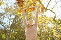 Young Girl Throwing Autumn Leaves In The Air