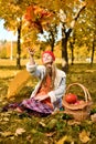 Young girl throws a bouquet of autumn leaves