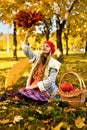 Young girl throws a bouquet of autumn leaves