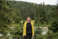 Young girl tourist on the background of mountains, coniferous forest and mountain river during a trip to the Carpathians Royalty Free Stock Photo