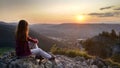 Young girl tourist looks at sunset over Zakopane from the top of the mountain, Poland, High Tatras Royalty Free Stock Photo
