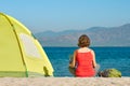 Young girl tourist sit near the tent looking the map