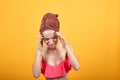 Young girl with towel on her head over isolated orange background shows emotions Royalty Free Stock Photo