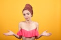 Young girl with towel on her head over isolated orange background shows emotions Royalty Free Stock Photo