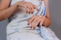 Young girl in towel putting cream on hands. Royalty Free Stock Photo