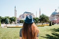 A young girl traveler in a hat from the back in Sultanahmet Square next to the famous Aya Sofia mosque in Istanbul Royalty Free Stock Photo