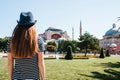 A young girl traveler in a hat from the back in Sultanahmet Square next to the famous Aya Sofia mosque in Istanbul Royalty Free Stock Photo