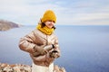 A young girl traveler pours hot tea into a mug from a thermos in nature.