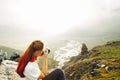 A young girl traveler takes pictures of a summer mountain landscape. Elbrus region, Russia. Woman Emancipation Concept