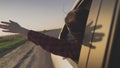 A young girl travels by car on the road, stretch out his hand through the window, catch the wind, enjoying the nature Royalty Free Stock Photo