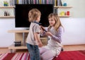 Young girl trying to get the remote control from her small broth Royalty Free Stock Photo