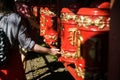 Girl twists a prayer drum in a Buddhist temple. Red khurde in the sun. Mani drum