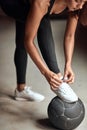 Young girl tying up running shoe in gym Royalty Free Stock Photo