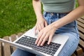 A young girl types on the keyboard of a laptop, computer.