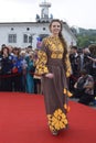 Young girl in Ukrainian national embroidered dress posing in front of a crowd of people. Celebration of Embroidered