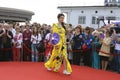 Young girl in Ukrainian national embroidered dress posing in front of a crowd of people. Celebration of Embroidered