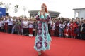 Young girl in Ukrainian national embroidered dress posing in front of a crowd of people. Celebration of Embroidered