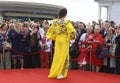 Young girl in Ukrainian national embroidered dress posing in front of a crowd of people. Celebration of Embroidered