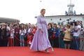 Young girl in Ukrainian national embroidered dress posing in front of a crowd of people. Celebration of Embroidered