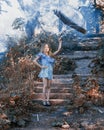 Young girl with umbrella in hand, on the stairs, which meets the bright, blue smoke.