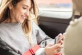 Young girl uses a mobile phone in the car Royalty Free Stock Photo