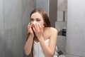 Young girl uses nose strips to remove black dots. Girl takes care of the facial skin in the bathroom every morning