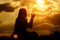 A young girl uses a smartphone to take pictures. Black silhouette against the sunset sky