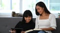 Young girl using digital tablet doing homework online during extra curricular classes with her tutor.